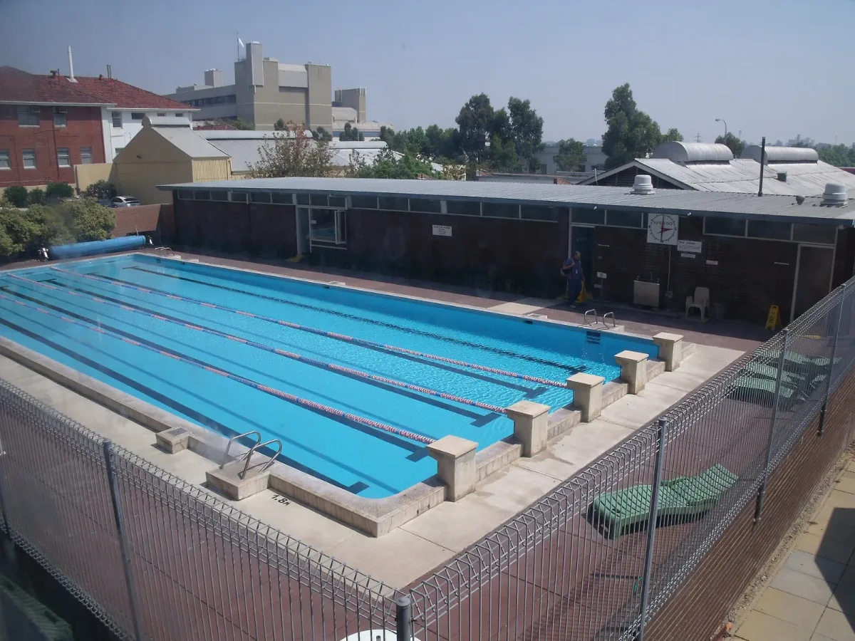Gard din plasa bordurata verde montat pe stalpi metalici in jurul unei piscine, vedere de sus